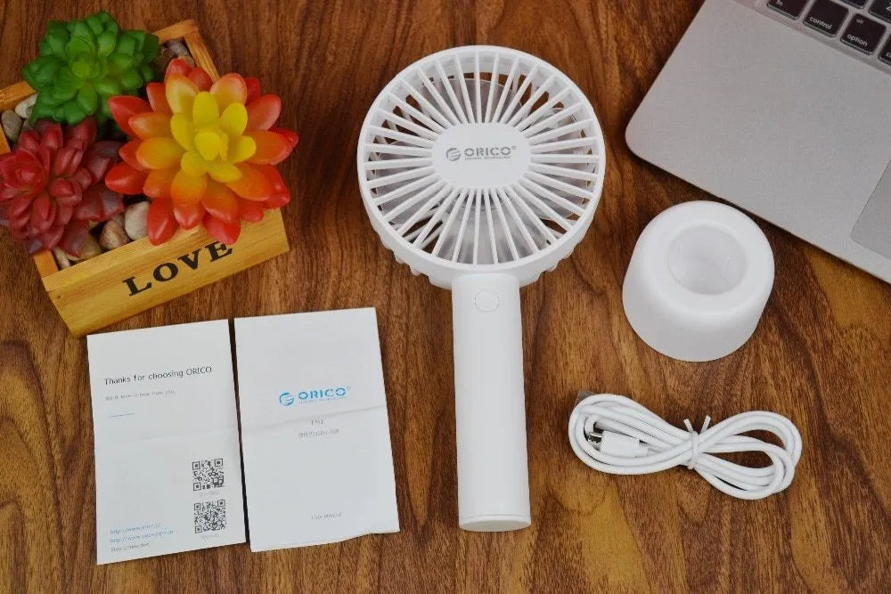 White ORICO FH1 portable USB desk fan with rechargeable battery on a wooden desk
