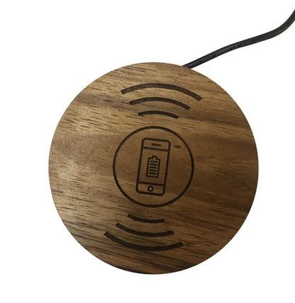 Round wireless charging unit for recessed installation in desks and tables, shown next to a smartphone.