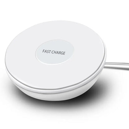 White wireless charging pad with digital clock display, alarm, and LED night light on a bedside table.
