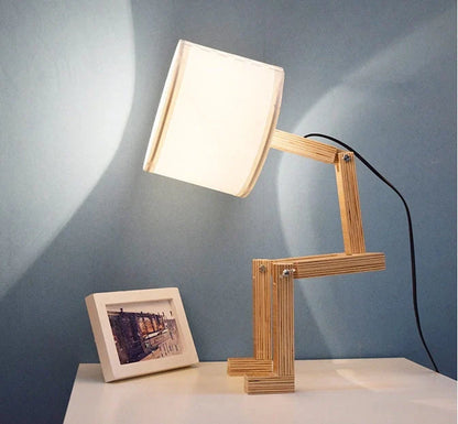 Humanoid wooden table lamp with deformable design and fabric shade for modern home decor