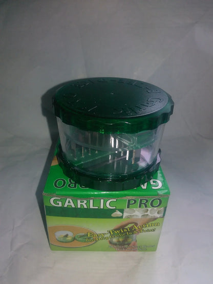 Green manual garlic peeler kitchen tool with silicone roller and plastic press handle.