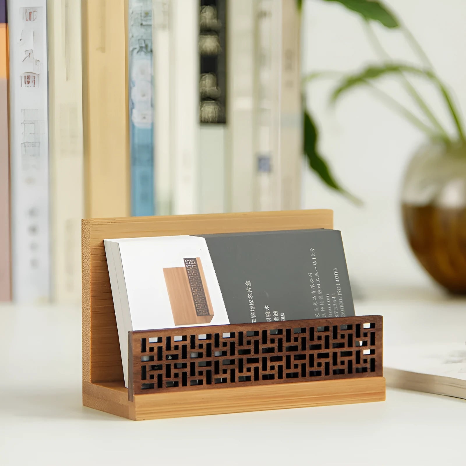Geometric bamboo and black walnut wood business card holder on a desk.