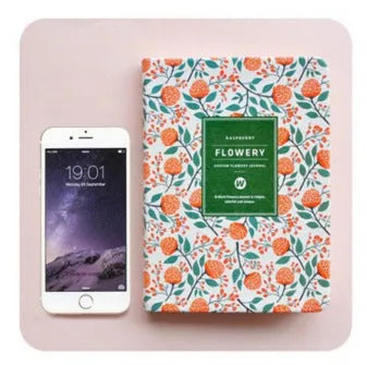 Bo Shide floral notepad with fabric-imitation leather cover in green, shown open on a desk.