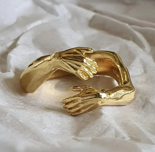 Adjustable geometric love hands embracing ring in gold and silver, perfect for gifts.