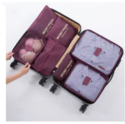 Set of six coloured nylon packing cubes and flat pouches for travel organisation.