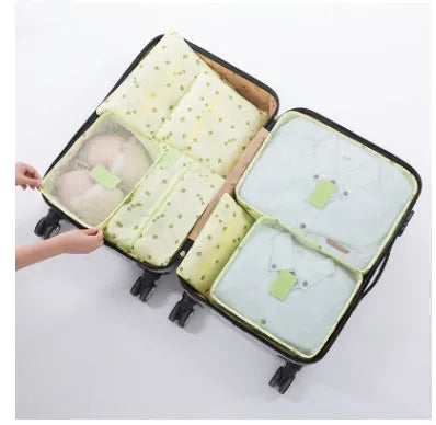 Set of six coloured nylon packing cubes and flat pouches for travel organisation.