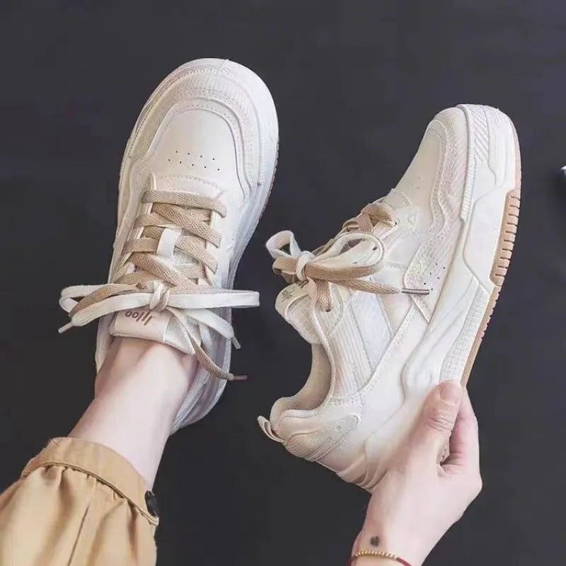 Women's beige and pink low-top sneakers with a rubber sole featuring hidden height increase.