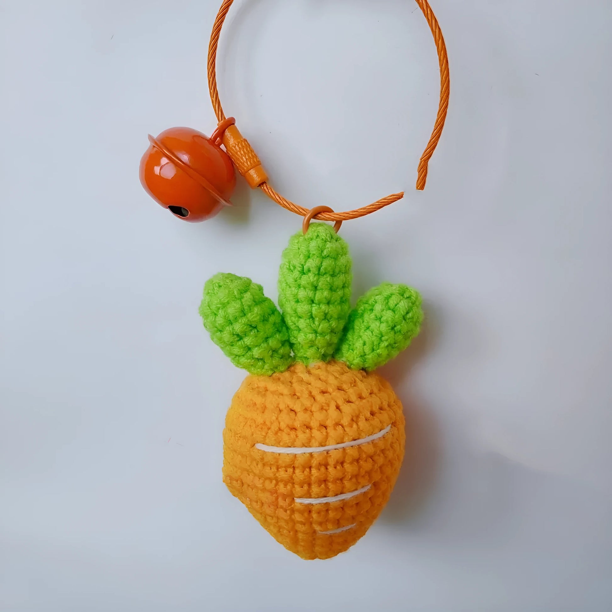 Cartoon carrot car design wool felt keychain pendant on a keyring.