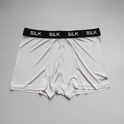 Men's loose-fitting silk shorts in navy blue on a neutral background.