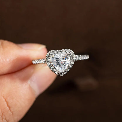 Women's heart-shaped crystal wedding ring in rose gold or silvery on a white background.