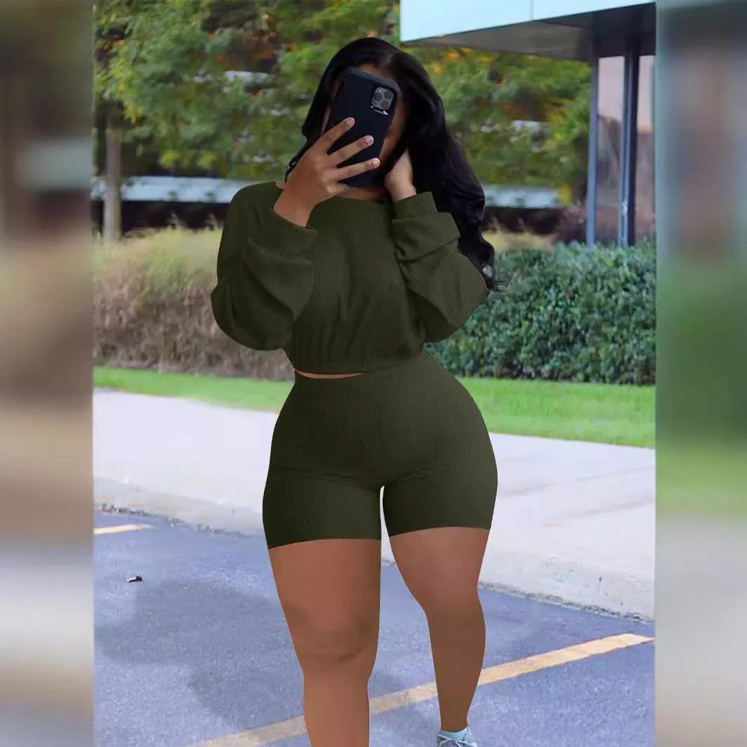 Women's long sleeve off-the-shoulder top and shorts two-piece set in a solid colour.