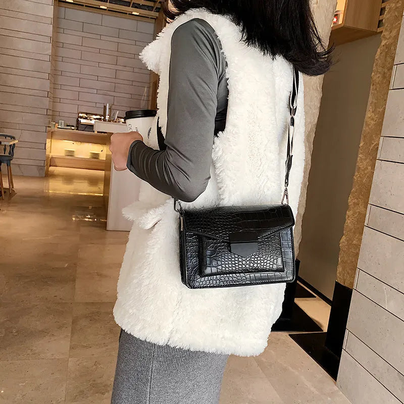 Vintage crossbody bag in black showing 20cm width, crossbody strap, and front storage compartment