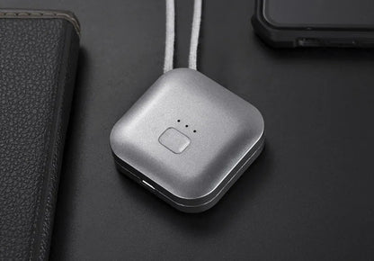 Pink wearable USB air purifier necklace on a table with USB cable, showing compact size.
