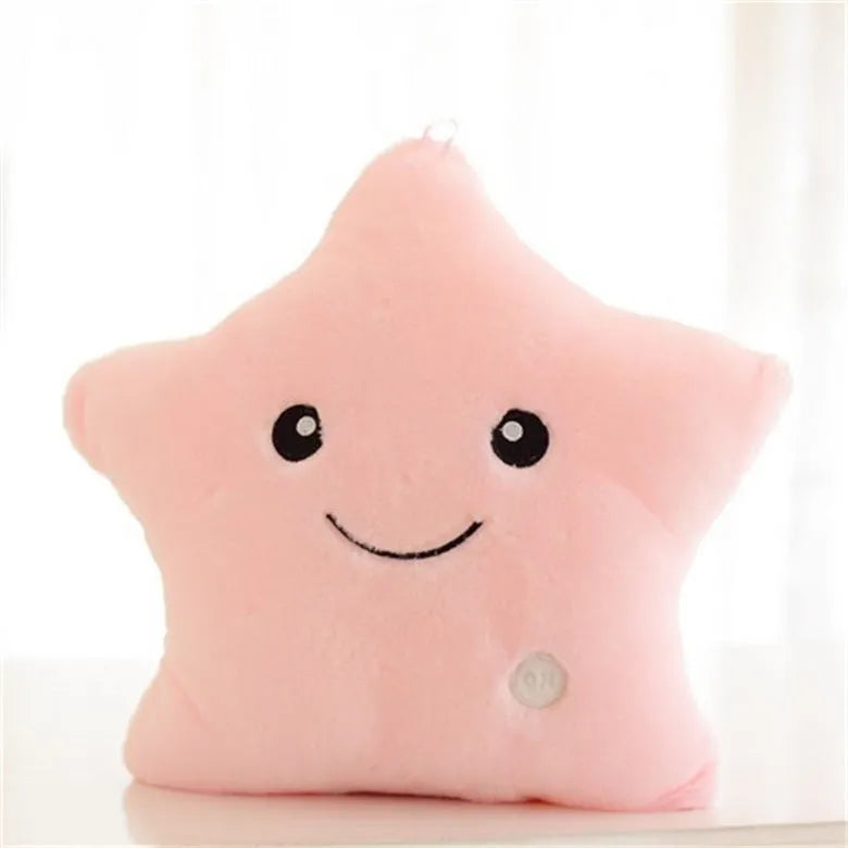 Colourful glowing five-pointed star plush pillow on a dark background.