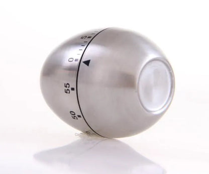 Stainless steel mechanical kitchen timer with egg-shaped design on kitchen counter
