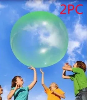Large pink, yellow, green, and blue inflatable bouncy balls in various sizes for children's play.