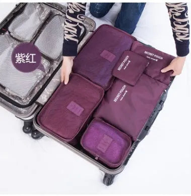 Set of six coloured nylon packing cubes and flat pouches for travel organisation.
