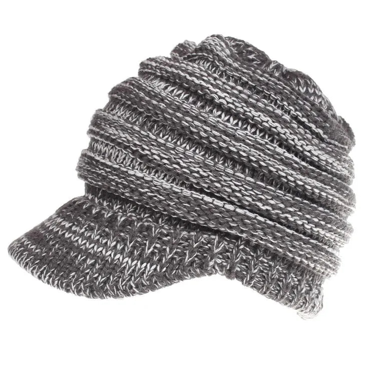 Woman wearing a light grey knitted ponytail beanie with her ponytail pulled through the hole in the back.