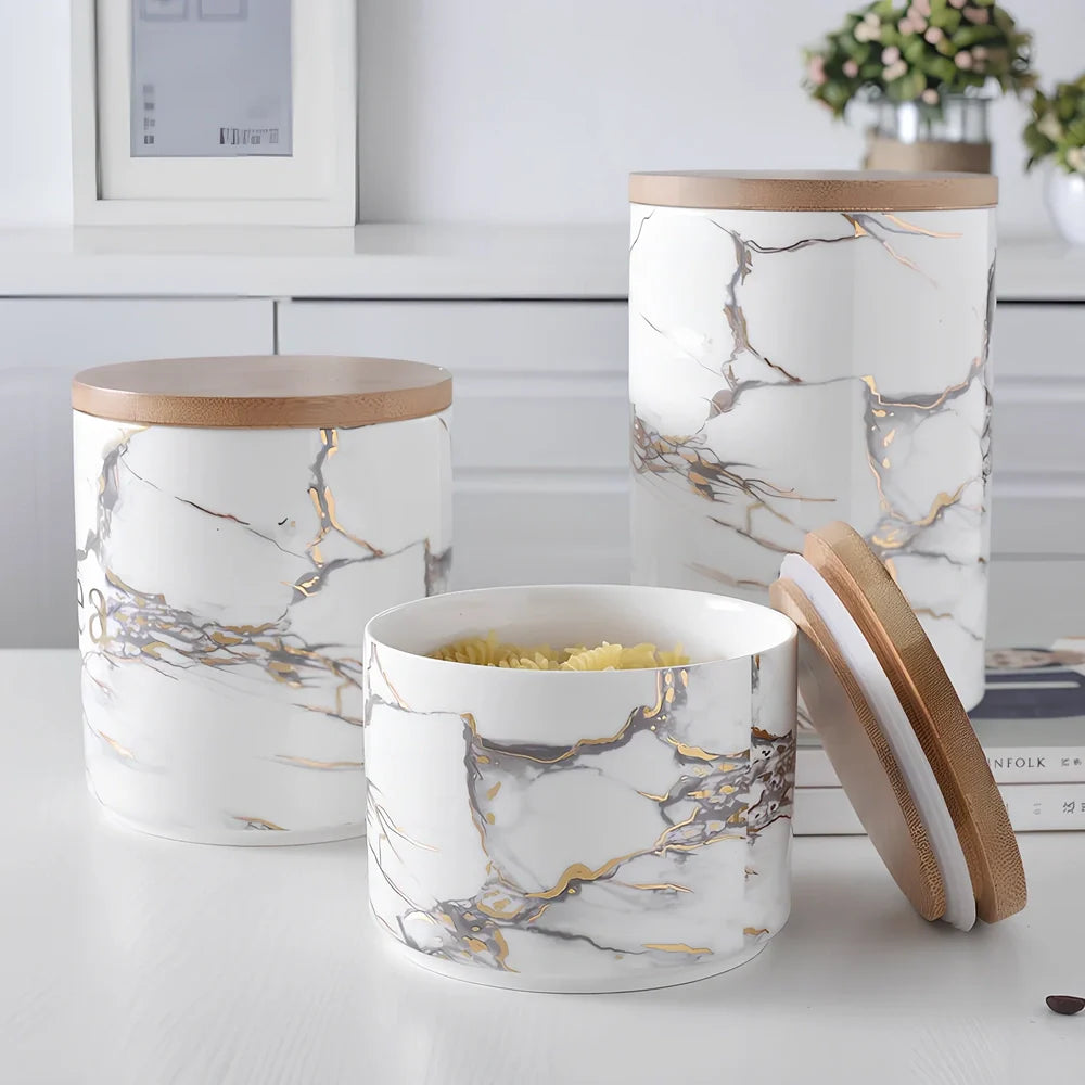 Three marbled ceramic storage jars with wooden lids showing large, medium, and small sizes