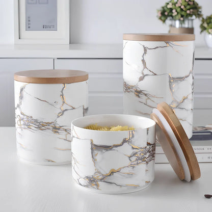 Three marbled ceramic storage jars with wooden lids showing large, medium, and small sizes