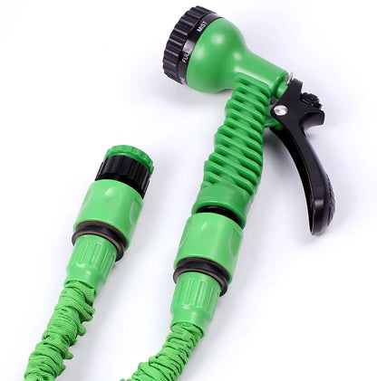 Expandable flexible water hose with spray gun showing green colour and extended length with water spraying in cone pattern