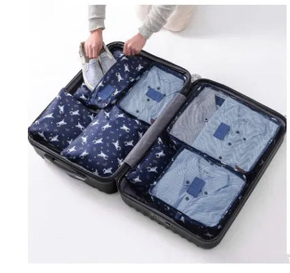 Set of six coloured nylon packing cubes and flat pouches for travel organisation.