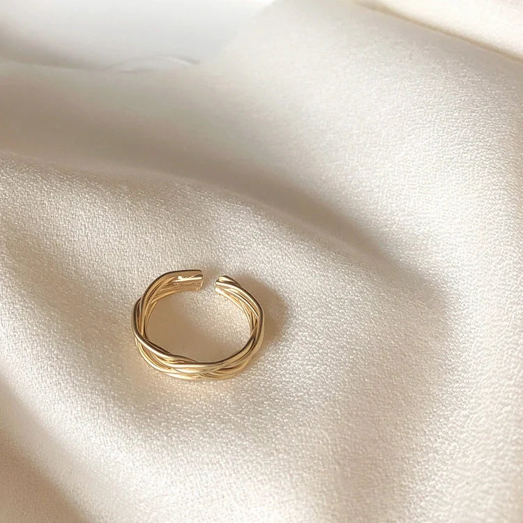 Adjustable twist metal ring in a gold tone, featuring a modern geometric design with a vintage-inspired flair.