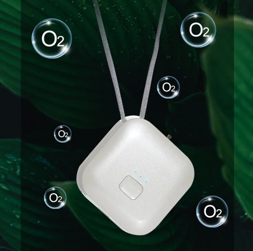 Pink wearable USB air purifier necklace on a table with USB cable, showing compact size.