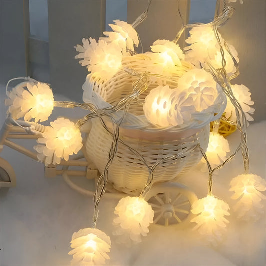 Warm white LED pine cone fairy light string on a green backdrop, showing plastic shell details.
