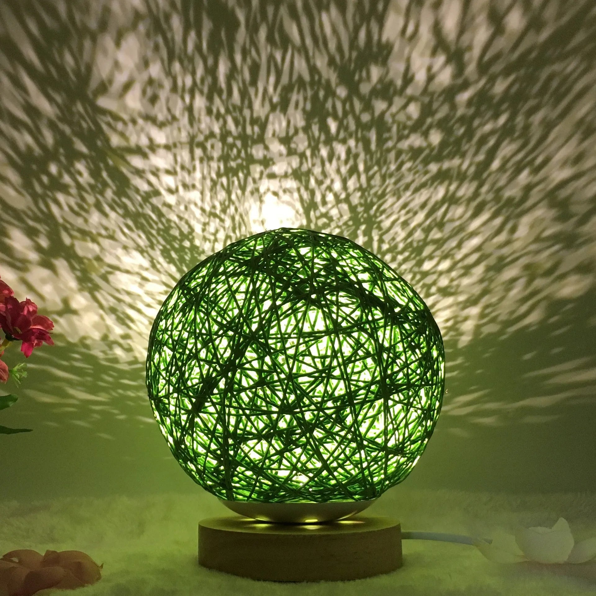 Spherical hand-knitted rattan table lamp with remote control on a wooden desk