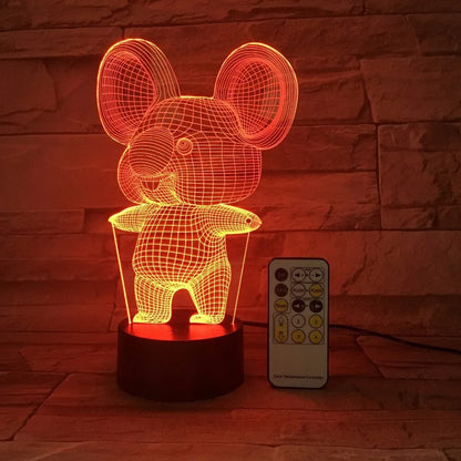 Black Koala night light with LED illumination on a bedside table.