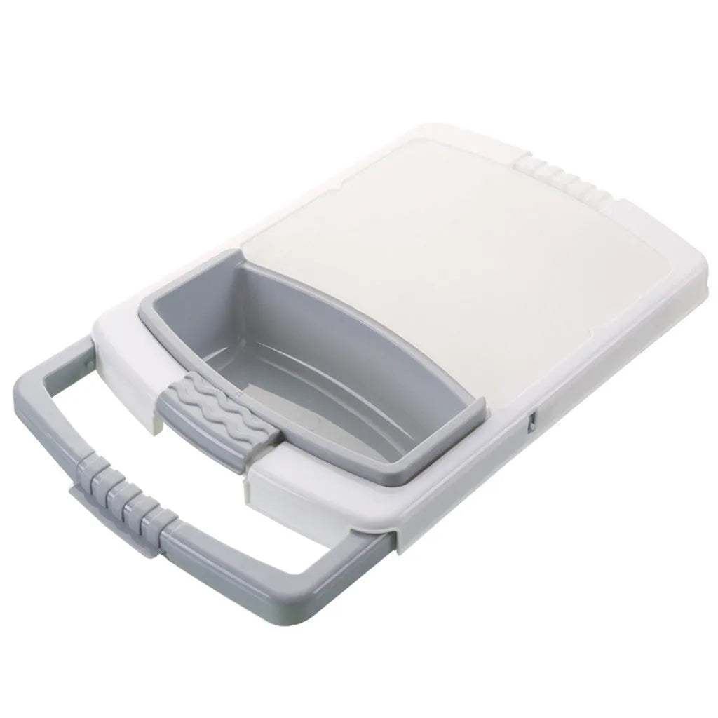 Green multifunction cutting board with drainage holes and storage trough mounted on a kitchen sink.