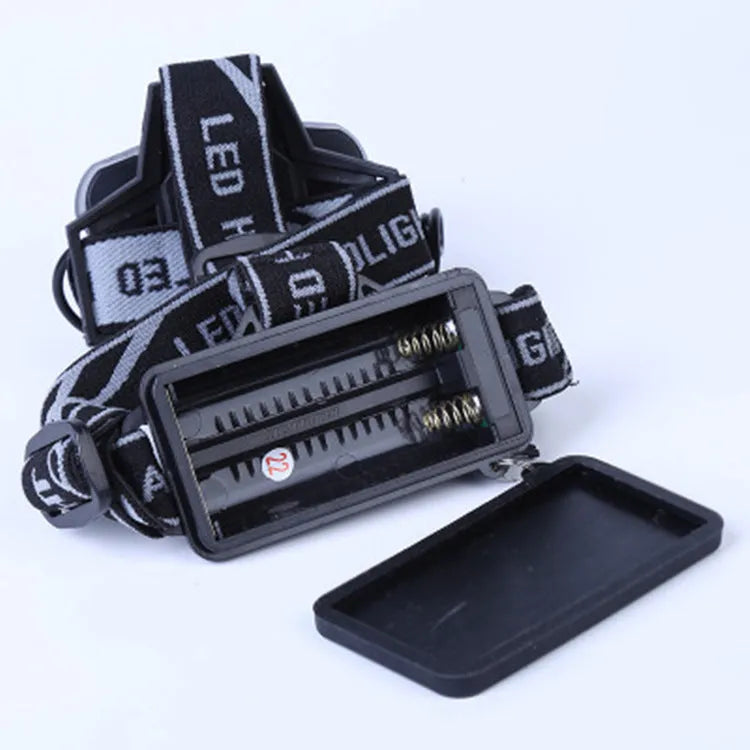 Fixed focus head torch for camping with long-range LED beam, shown with charger.