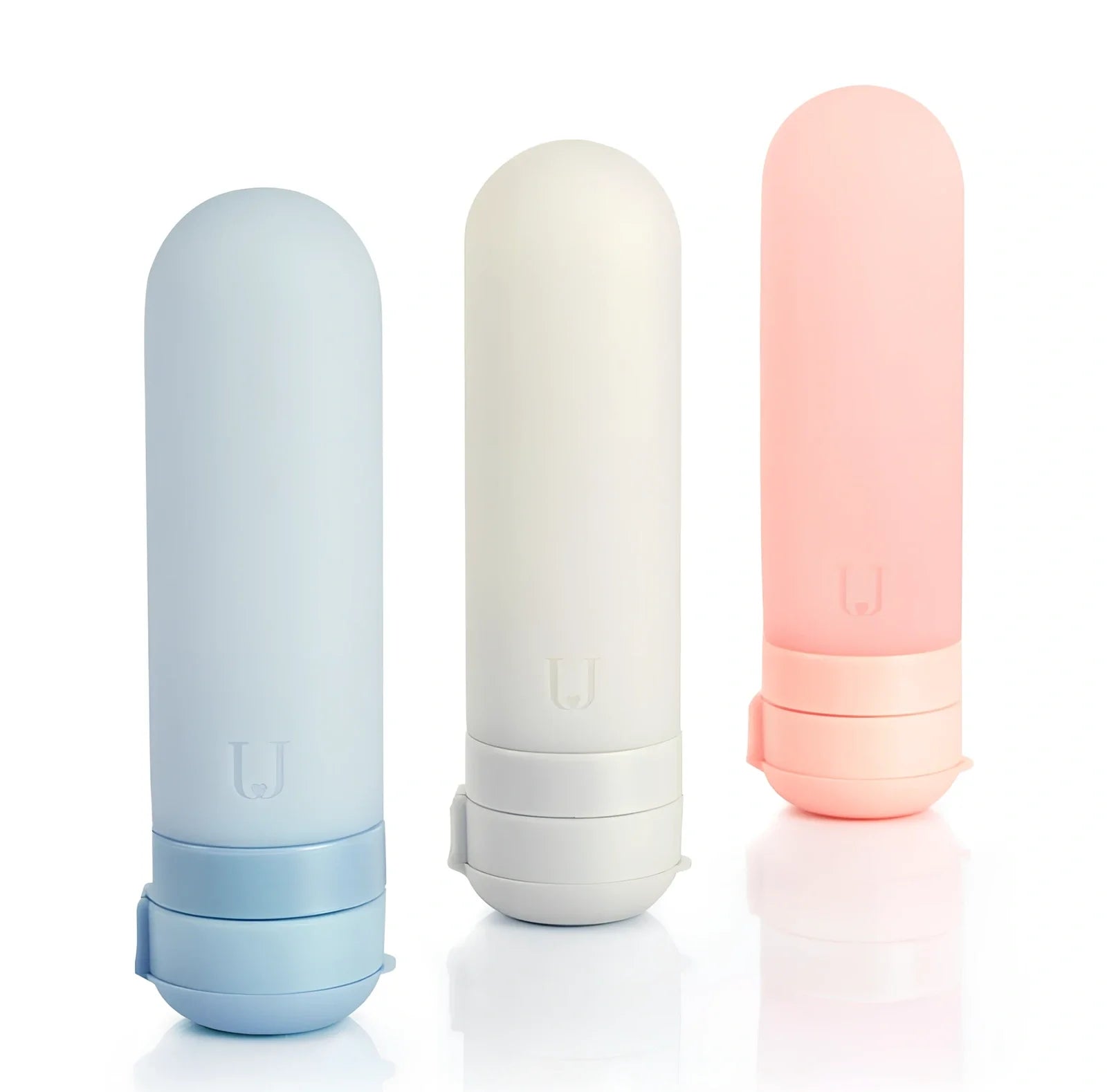 Set of three silicone travel bottles in light grey, pink, and blue colours with screw caps