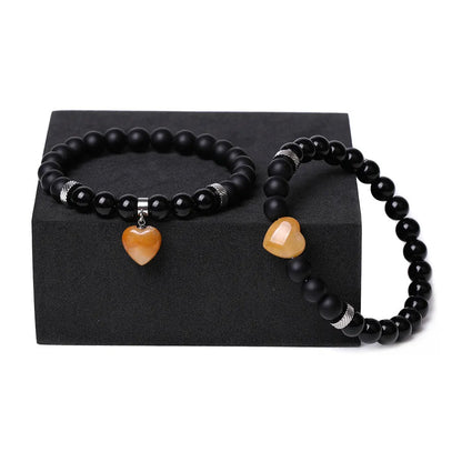 Matching couple bracelets with polished natural stone heart pendants in geometric style