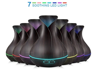 Black USB humidifier with colour-changing LED lights and water mist output, 15cm tall on wooden desk