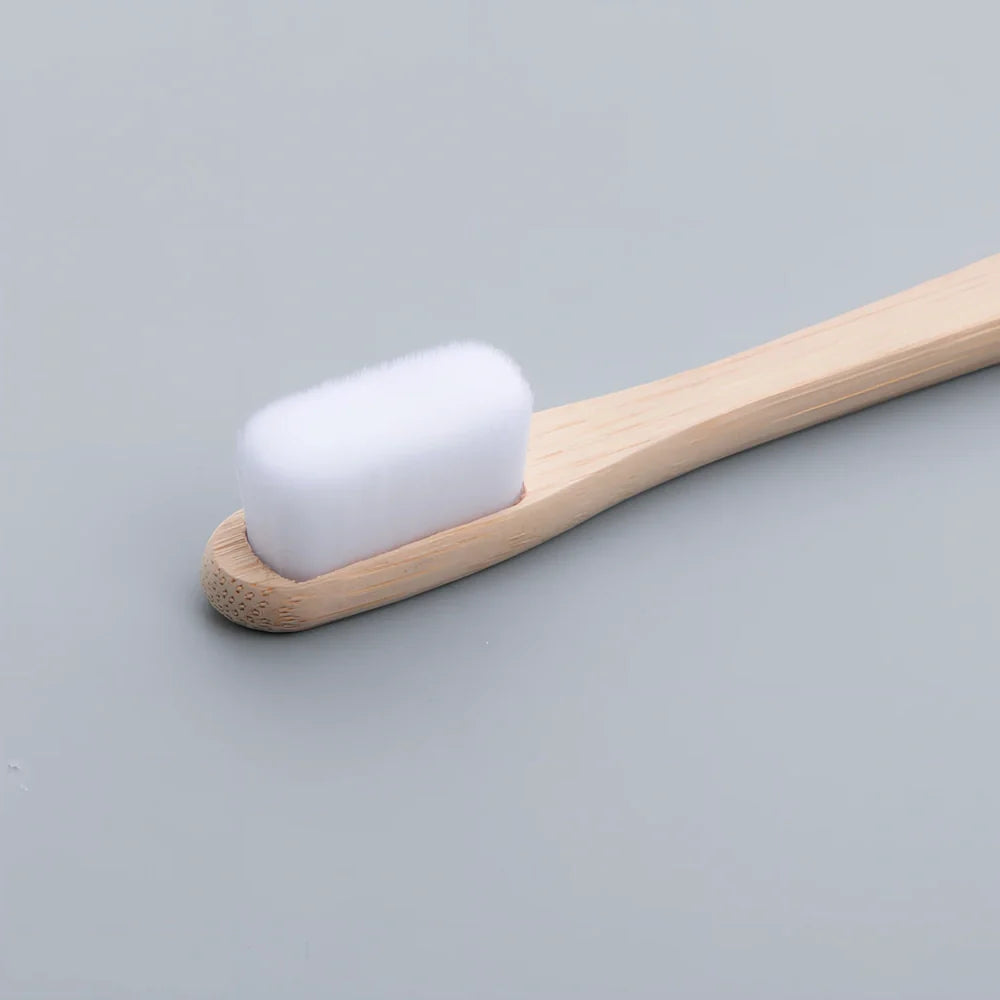 Bamboo toothbrush with wood colour handle measuring 18.5cm long with soft white bristles in protective tube