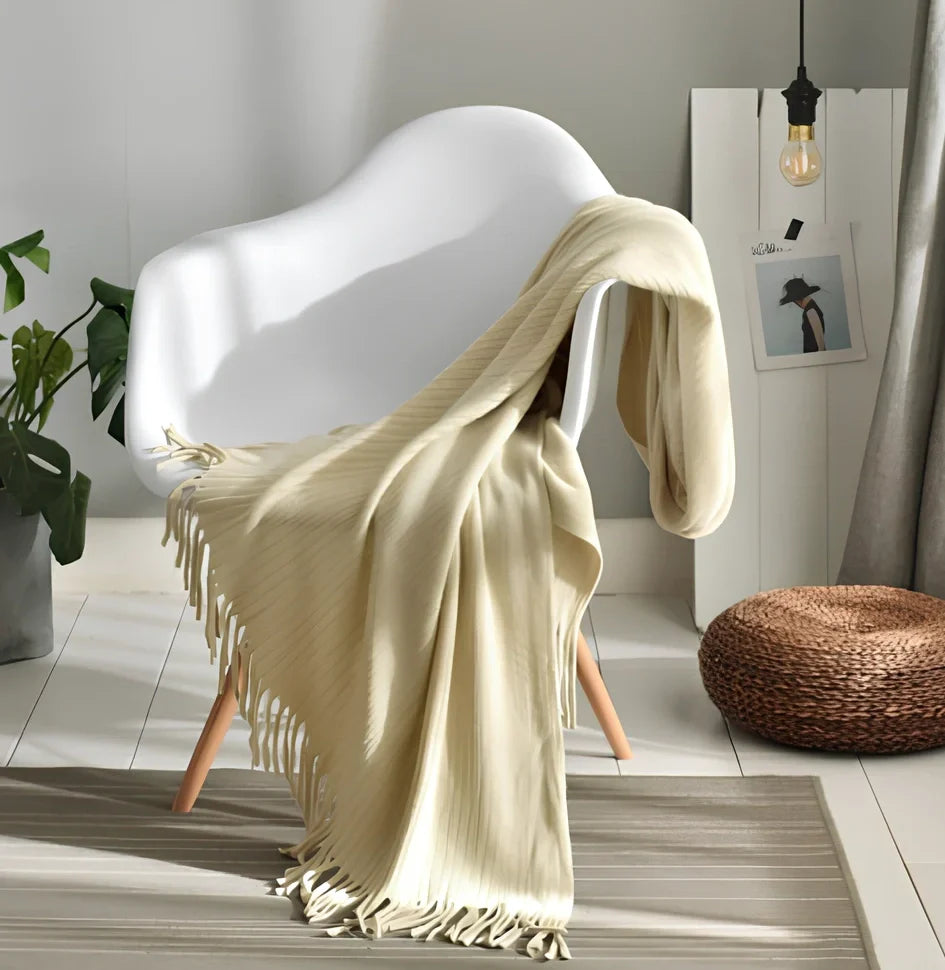 130x150cm knitted acrylic blanket with 10cm fringe detailing in beige colour draped over sofa