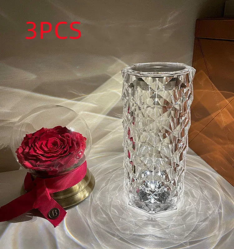 Modern minimalist acrylic crystal rose LED table lamp with touch switch on a wooden table.