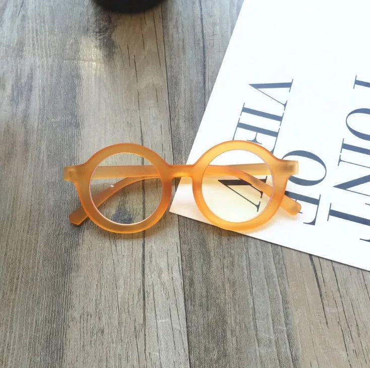 Retro round frame anti blue light glasses in various colours on a plain background