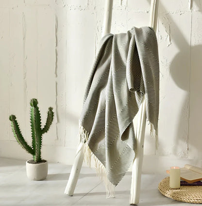 130x150cm knitted acrylic blanket with 10cm fringe detailing in beige colour draped over sofa