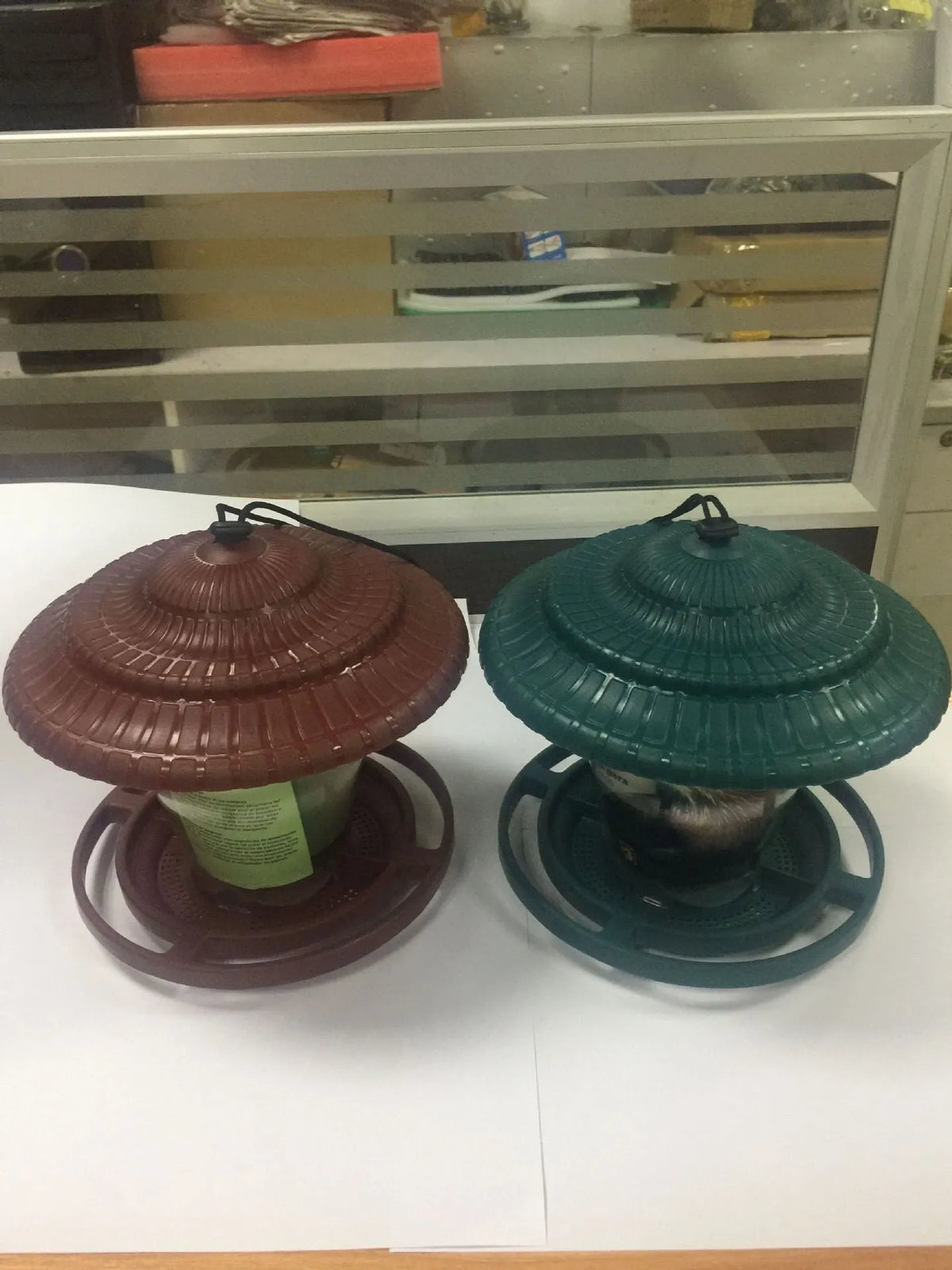 Hanging plastic transparent bird feeder, 18cm x 18cm x 19cm, shown in green or red.