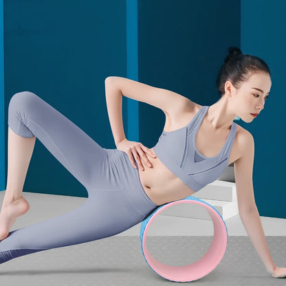 Pink yoga wheel with 31.5cm diameter and 12.2cm width for back-bending exercises