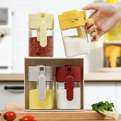 Small glass seasoning jars with lids and spoons in various colors for kitchen organization