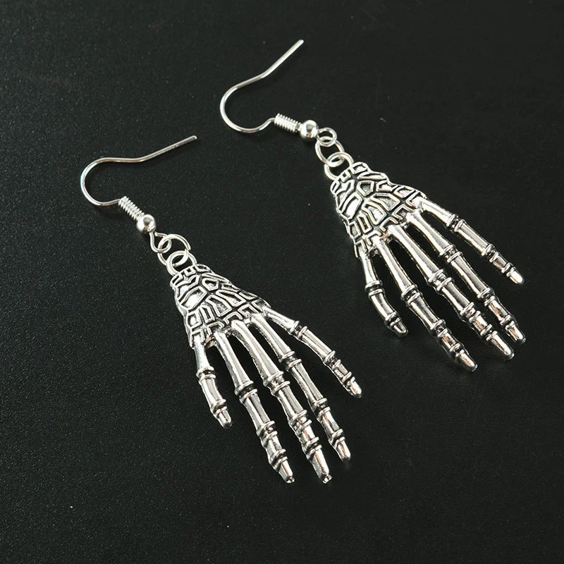 Vintage-inspired skull and skeleton earrings with intricate enamel details and a spooky-chic design