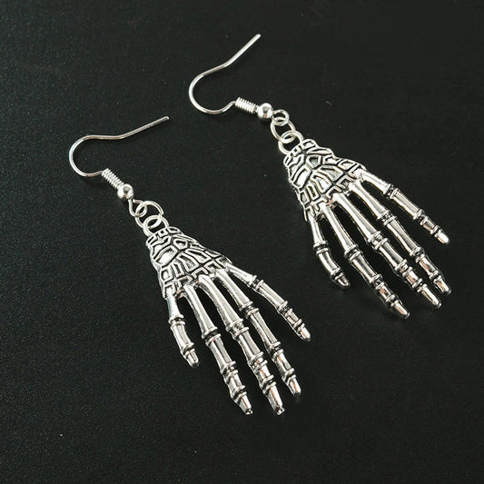 Vintage-inspired skull and skeleton earrings with intricate enamel details and a spooky-chic design