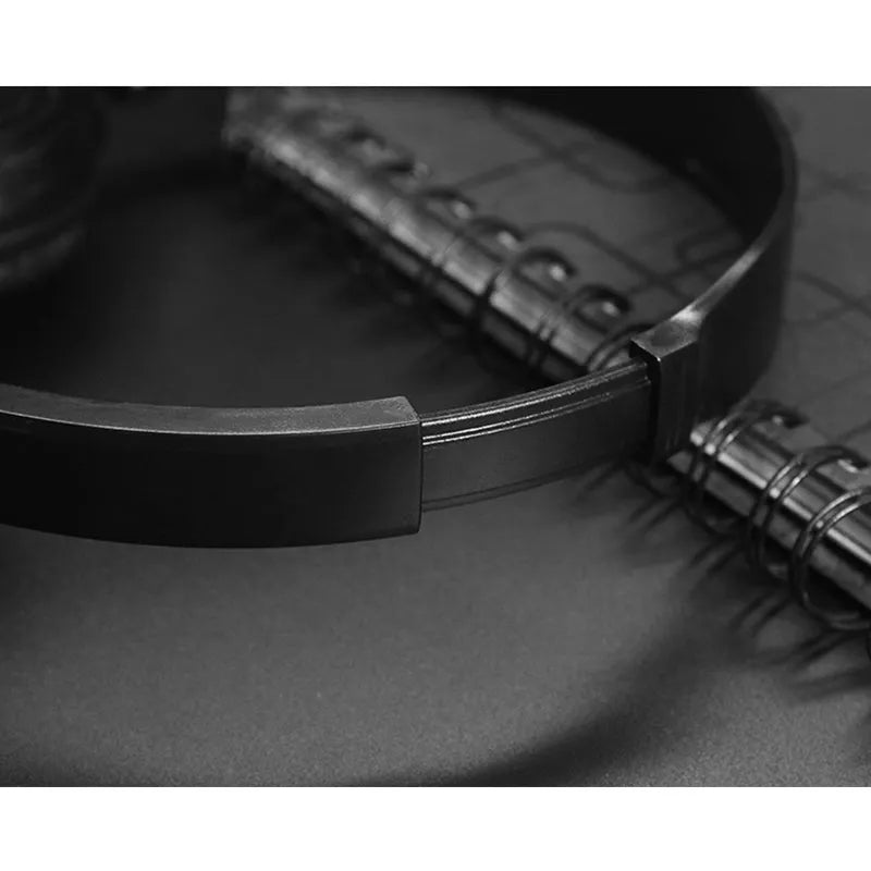 Black folding over-ear wired headphones with adjustable headband and 3.5mm plug on a white background.