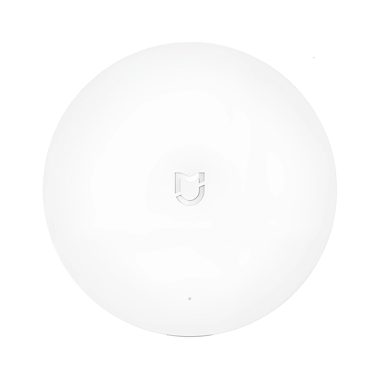 White circular Xiaomijia smart home gateway with UK plug on a wall.
