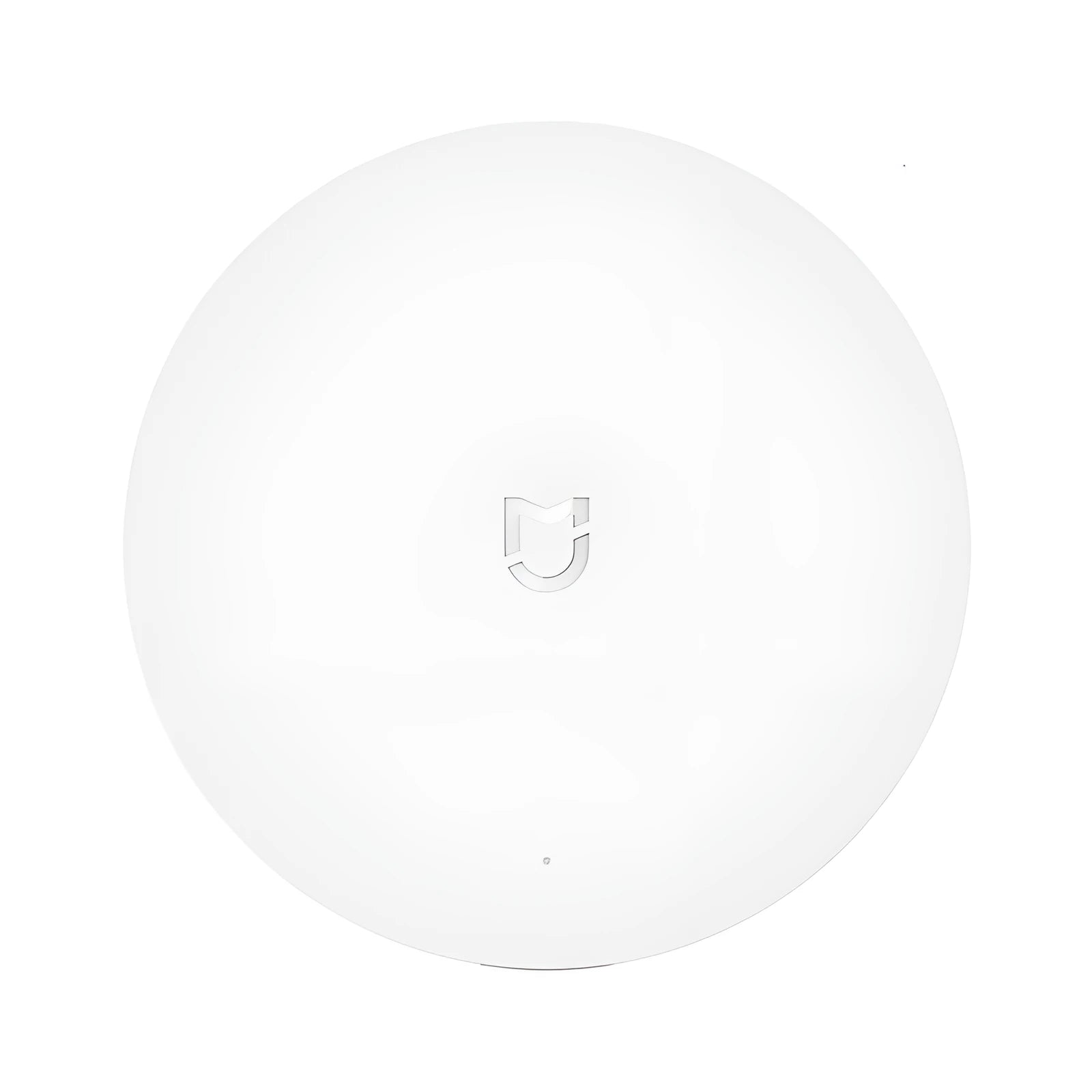 White circular Xiaomijia smart home gateway with UK plug on a wall.