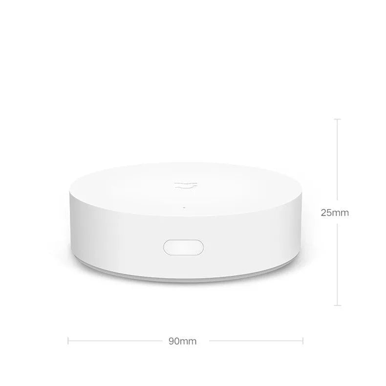 White circular Xiaomijia smart home gateway with UK plug on a wall.